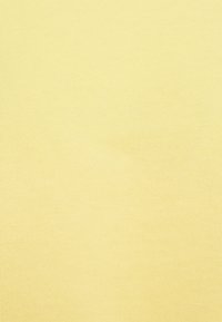 Tissu en coton jaune clair avec une texture côtelée, apparence uniforme sans motifs ni accents, présentant une surface douce et lisse.