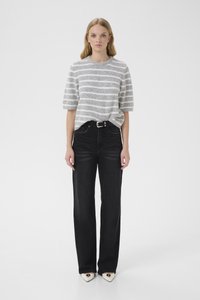 Γκρι και λευκό ριγέ πλεκτό πουλόβερ με κοντά μανίκια, συνδυασμένο με μαύρο τζιν ψηλόμεσο και λευκά παπούτσια με μυτερή μύτη και μαύρες λεπτομέρειες.