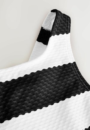 Material cu dungi alb-negru, având un model texturat. Dispune de o curea robustă cu o margine contrastantă de culoare neagră și detalii subtile de coasere.