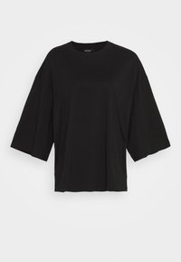 T-shirt nero oversize con maniche corte a pipistrello, scollo rotondo e tessuto liscio e elasticizzato. Nessun motivo o dettaglio visibile.