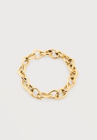 Βραχιόλι με χοντρούς κρίκους σε χρυσό τόνο, με ακανόνιστους οβάλ κρίκους, απεικονισμένο σε απλό ανοιχτό γκρι φόντο.