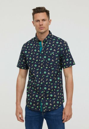 Chemise à manches courtes en coton bleu marine avec un imprimé de fruits et de feuilles verts. Dotée d'un col boutonné et d'une patte de boutonnage turquoise contrastante.