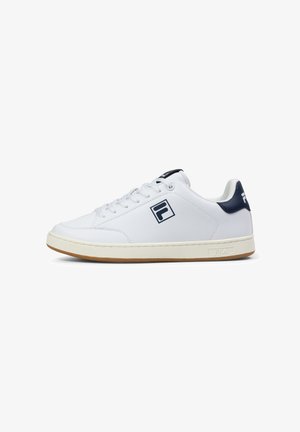 White leather sneakers with a rubber sole, navy accents, a stitched seam, and a logo on the side. Rounded toe design and lace-up closure.