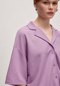 Lavendel shirt met korte mouwen en een gekarteld kraagje, met een knoopsluiting en een relaxte pasvorm. Gemaakt van zachte, gestructureerde katoen.