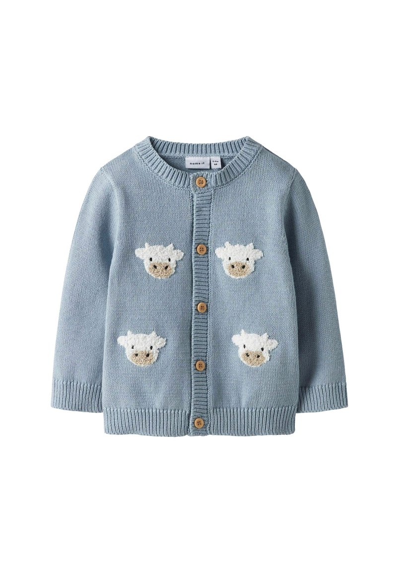 Hellblauer Cardigan, gestrickter Stoff, runder Halsausschnitt, fünf Holzknöpfe und vier Schaf-Applikationen in Weiß und Beige auf der Vorderseite.