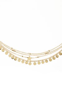 Gold multi-layer necklace featuring various chain lengths, round disks, and a star pendant, all with a polished, shiny finish.