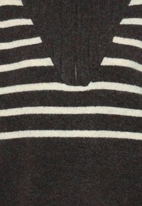 Pull en tricot avec des rayures horizontales grises foncées et blanches, doté d'un design en V et d'une fermeture à mi-zip au col. Texture douce.