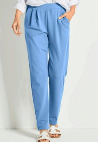 Hellblaue Hose mit lockerer Passform, breitem elastischen Bund, zwei seitlichen Taschen und einem glatten, leichten Stoff.