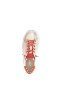 Baskets dorées métalliques avec lacets et accents orange. Elles présentent un bout arrondi et un col rembourré, fabriquées à partir de matériaux en cuir et textile.