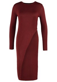 Rippkleid mit langen Ärmeln in einem tiefen Burgunderrot, mit asymmetrischem Saum und strukturiertem Strickstoff für zusätzliche Dimension.