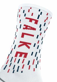 Calze bianche con un motivo testurizzato in rosso e blu navy, con la parola "FALKE" in evidenza. Il design incorpora linee verticali tratteggiate.