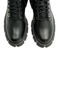 Botas de tobillo de cuero negro con acabado texturizado, con puntera redonda, cordones en la parte delantera, ojales dorados y suela de goma negra resistente.
