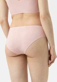 Lichtroze naadloze ondergoed met een gladde textuur en een low-rise ontwerp. Minimalistische stijl, geen zichtbare naden of versieringen.