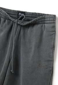Grijze sweatpants van zachte stof, met een elastische tailleband met trekkoord en een geborduurd "Utopia" logo op het linkerpand.