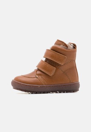 Bottine en cuir marron avec un bout arrondi, trois sangles Velcro et une doublure douce. Semelle en caoutchouc robuste avec un motif texturé pour une bonne adhérence.