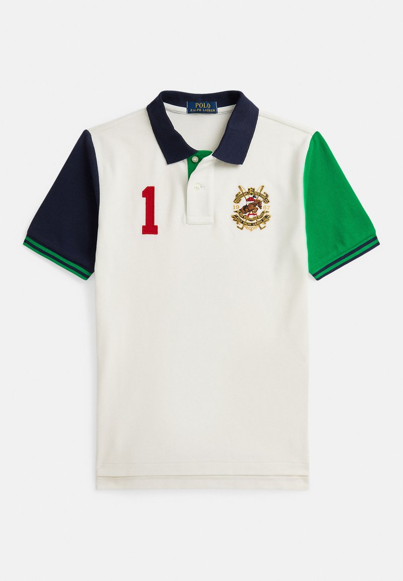 Camiseta polo branca com mangas azul-marinho e verdes, gola azul-marinho, número vermelho "1" no peito e brasão Ralph Lauren bordado no lado esquerdo.