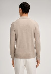 Beige langärmlige Strickjacke aus weichem Material, mit geripptem Saum, Kragen und glatter Textur, von hinten betrachtet.