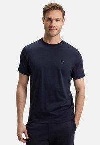 T-shirt bleu marine à manches courtes fabriqué en tissu doux, avec un col rond et un petit logo sur la poitrine. Design simple et uni.