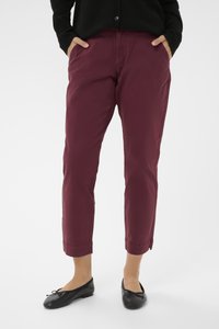 Burgundy cotton blend pants with tapered legs, side pockets, and cuffed hems. Paired with black ballet flats.