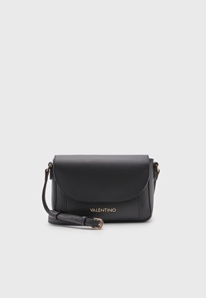 Sac bandoulière Valentino en cuir noir avec fermeture à rabat et sangle ajustable sur un fond clair uni.