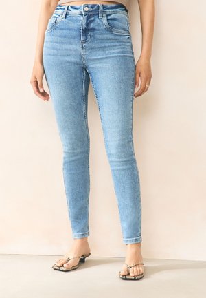 Světle modré úzké džíny s vysokým pasem, mají pět kapes a jemné zesvětlení. Materiál je denim s hladkou strukturou.