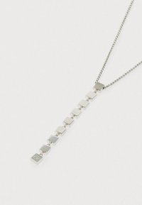 Sidabrinis pakabukas su geometriniu blokų dizainu, turintis pakaitomis blizgius ir matinius tekstūros elementus ant plono grandinėlės.