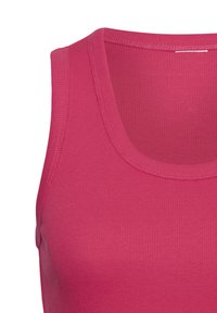 Canotta senza maniche rosa a coste con scollatura rotonda e superficie liscia, che evidenzia un primo piano dei dettagli del tessuto.
