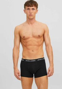 Schwarze Baumwoll-Boxershorts mit einem elastischen Bund, auf dem die Marke "JACK & JONES" in weißer Schrift steht. Figurschmeichelndes Design, weicher Stoff.