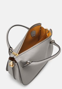 Grå läderhandväska med en strukturerad design. Har en dragkedja i guldton och inredning i varmt orange, med flera fack.