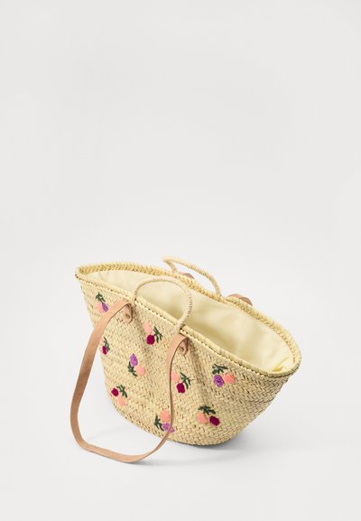 Sac cabas en paille tissée avec broderie florale, couleur beige, doublure jaune doux, anses en cuir et un large ouvrir en haut pour un accès facile.