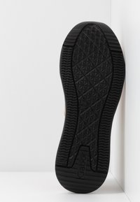 Semelle de chaussure en caoutchouc noir présentant un motif en diamant pour l'adhérence, avec un contour lisse et un logo embossé "Gabor" près du talon.