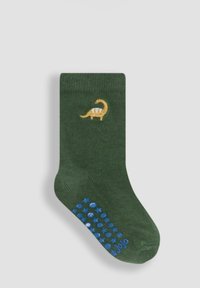 Calcetín infantil verde oscuro con pequeño bordado de dinosaurio amarillo y puntos antideslizantes azules en la suela.