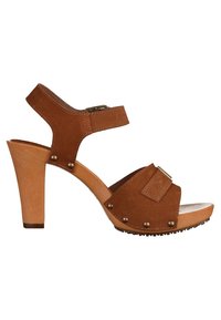 Sandale à talon haut en daim marron avec bride réglable à la cheville, semelle plateforme en bois et détails en clous bronze le long des bords.