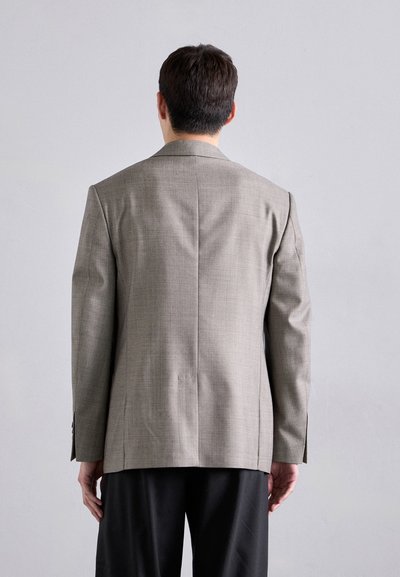 Grau strukturiertes Blazer mit einem Zwei-Knopf-Design, Rückenschlitz und langen Ärmeln; kombiniert mit dunklen Hosen. Maßgeschneidert für eine perfekte Passform.