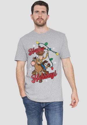 Graues T-Shirt mit einem Cartoon-Design eines Cowboys auf einem Pferd, umgeben von bunten Weihnachtslichtern, mit dem Text "Frohe Feiertage" in roten Akzenten.