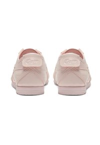 Jasnoróżowe sneakersy z gładkiego materiału, zaokrąglony kształt, wyraźne szwy i podniesione logo na zapiętku. Teksturowana gumowa podeszwa.