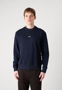 Mørkeblå sweatshirt laget av bomullsblanding, med rund hals, ribbestrikkede mansjetter og en liten hvit "BOSS"-logo på brystet.