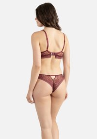 Ensemble bralette et thong en dentelle bordeaux avec des motifs floraux, des bretelles réglables et un fermoir à crochet au dos pour un maintien sécurisé.