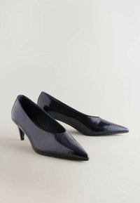 Escarpins en cuir verni marine avec un bout pointu et un talon chat de 7,5 cm, affichant une texture lisse et un design élégant.