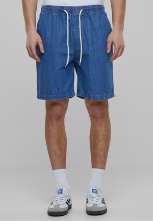 Denimshorts med elastisk midje og hvit snor, med en avslappet passform, lys blå farge og sydde kanter.
