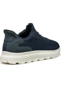 Granatowe sneakersy z teksturowanej dzianiny i gładkimi skórzanymi akcentami. Biała, wyściełana podeszwa z falistym wzorem bieżnika. Logo Geox na pięcie.