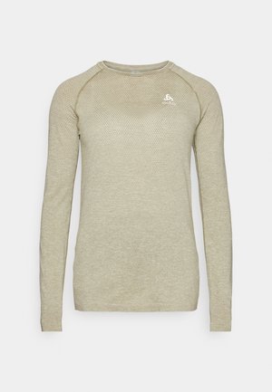 Μακρυμάνικο μπλουζάκι σε ανοιχτό μπεζ χρώμα, με υφή σε σχήμα κηρήθρας, στρογγυλή λαιμόκοψη και διακριτό λογότυπο στο στήθος. Φτιαγμένο από αναπνεύσιμο υλικό.