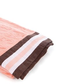 Asciugamano corallo con lettere strutturate e bordo a strisce marrone. Il design presenta due strisce più chiare di rosa e bianco sotto il marrone.