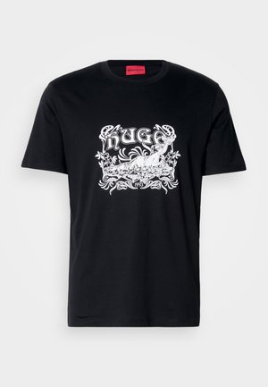 Melnas kokvilnas T-krekls ar baltu grafisko printu, kurā ir ziedu un dizaina elementi, un kurā ir redzams zīmola nosaukums "HUGO" un gads "1993."