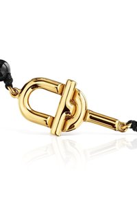 Cierre de toggles de metal en tono dorado con un acabado pulido y un cordón negro. Presenta una forma redondeada y una textura suave que refleja la luz.