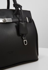 Black leather handbag with a textured surface, silver hardware, a detachable strap, and a zipper pull. Logo on the side reads "PICARD since 1928."