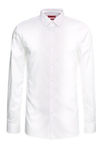 Camisa blanca de manga larga con cuello clásico, tapeta de botones y un bolsillo en el pecho. Confeccionada con tela de algodón suave. Diseño limpio.