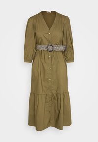 Oliwkowa sukienka z dekoltem w kształcie litery V, z guzikami z przodu, bufiastymi rękawami i warstwowym dołem. Zawiera pleciony czarno-biały pasek z okrągłą klamrą.