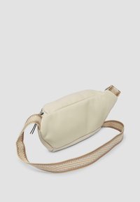 Crème synthetisch stoffen schoudertas met een gestructureerde vorm, voorzien van een gevlochten, tan kleurige strap en een ritsluiting aan de bovenkant.