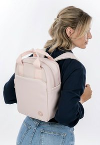Rosa, kompakt ryggsäck med dubbla handtag ovanpå, vadderade axelremmar och en framficka. Tillverkad av ett slätt material med minimalistisch design.